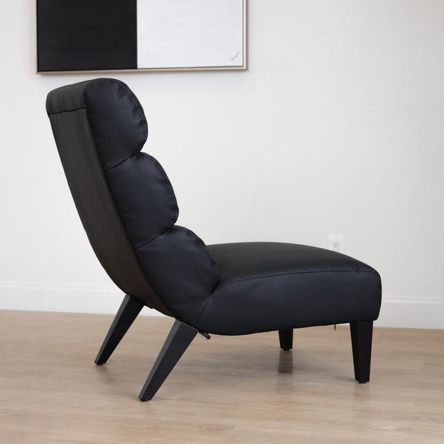 Fauteuil  en cuir végane noir avec dossier matelassé et pieds inclinés, style moderne pour salon. 
