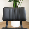 Deux chaises de salle à manger en cuir végane noir,  piètement en métal, design moderne, présentées dans un intérieur minimaliste.