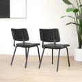 Deux chaises de salle à manger en cuir végane noir,  piètement en métal, design moderne, présentées dans un intérieur minimaliste.