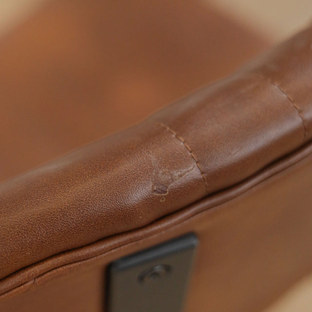 Deux chaises de salle à manger en cuir végane cognac, piètement métal noir, style industriel moderne.