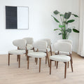 Chaises de salle à manger en tissu bouclé ivoire avec pattes en noyer foncé, style scandinave moderne.