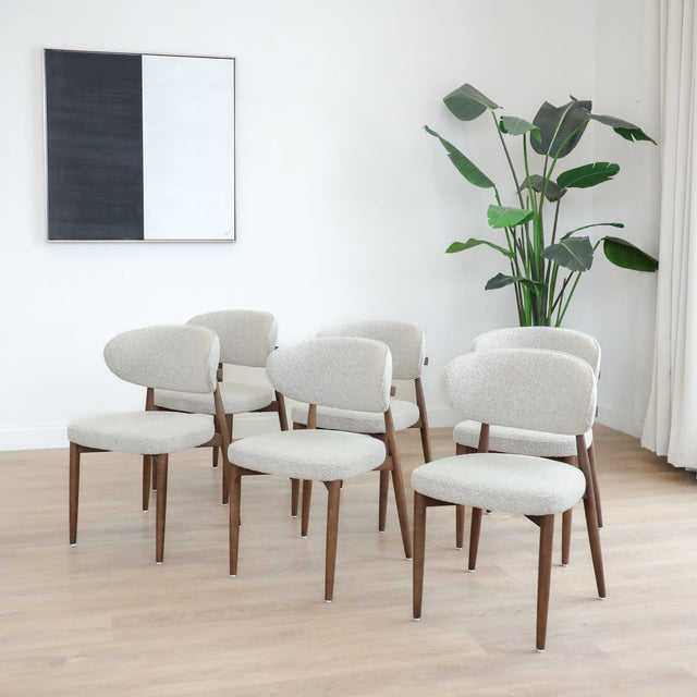 Chaises de salle à manger en tissu bouclé ivoire avec pattes en noyer foncé, style scandinave moderne.