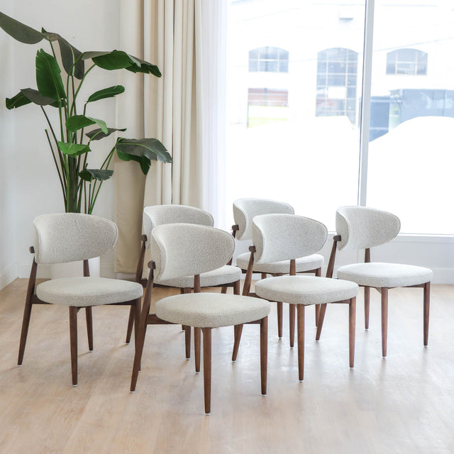 Chaises de salle à manger en tissu bouclé ivoire avec pattes en noyer foncé, style scandinave moderne.