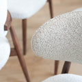 Chaises de salle à manger en tissu bouclé ivoire avec pattes en noyer foncé, style scandinave moderne.