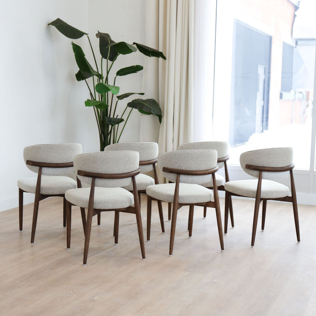 Chaises de salle à manger en tissu bouclé ivoire avec pattes en noyer foncé, style scandinave moderne.