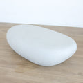 Table basse design en béton blanc, forme galet organique, idéale pour salon moderne et épuré.