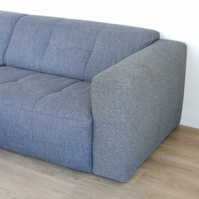 Modulaire deux places en tissu gris foncé avec chaise longue gauche, design moderne et lignes épurées pour salon contemporain.