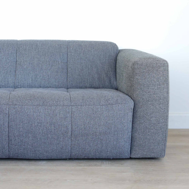 Modulaire deux places en tissu gris foncé avec chaise longue gauche, design moderne et lignes épurées pour salon contemporain.