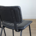 Lot de trois chaises de salle à manger noires en cuir végane noir avec piètement en métal noir, style moderne minimaliste.