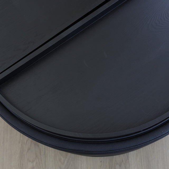 Ottoman avec plateau amovible en bois noir et base rembourrée, idéale pour salon moderne et fonctionnel.