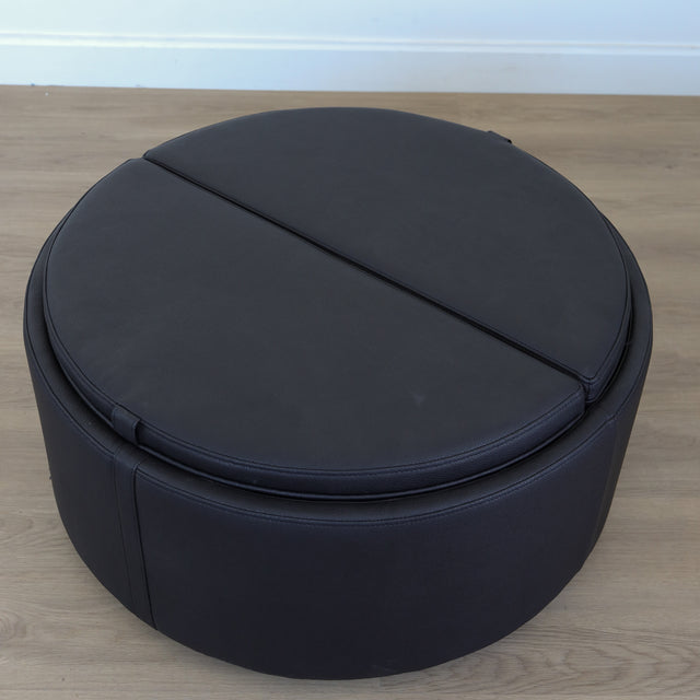 Ottoman avec plateau amovible en bois noir et base rembourrée, idéale pour salon moderne et fonctionnel.