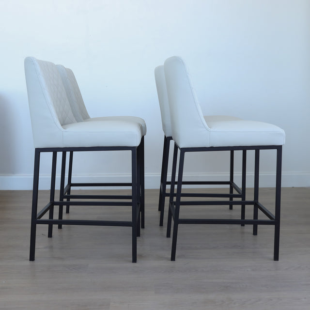 Lot de tabourets matelassés avec piétements noirs, style moderne.