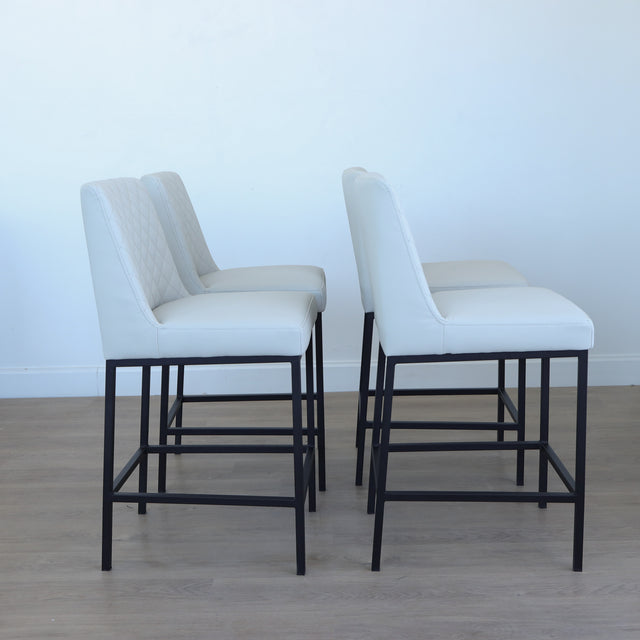 Lot de tabourets matelassés avec piétements noirs, style moderne.