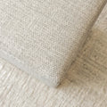 Ottoman cube beige en tissu texturé, idéal comme assise ou table d’appoint dans un salon moderne.