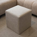 Ottoman cube beige en tissu texturé, idéal comme assise ou table d’appoint dans un salon moderne.