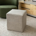 Ottoman cube beige en tissu texturé, idéal comme assise ou table d’appoint dans un salon moderne.