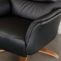 Fauteuil en cuir noir avec appui-tête et base bois pivotante, dans un intérieur chaleureux.