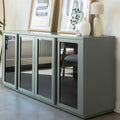 Buffet moderne vert sauge à portes vitrées fumées, décoré d’objets design dans un intérieur contemporain lumineux.