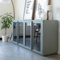 Buffet moderne vert sauge à portes vitrées fumées, décoré d’objets design dans un intérieur contemporain lumineux.