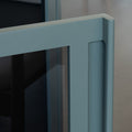 Buffet moderne vert sauge à portes vitrées fumées, décoré d’objets design dans un intérieur contemporain lumineux.