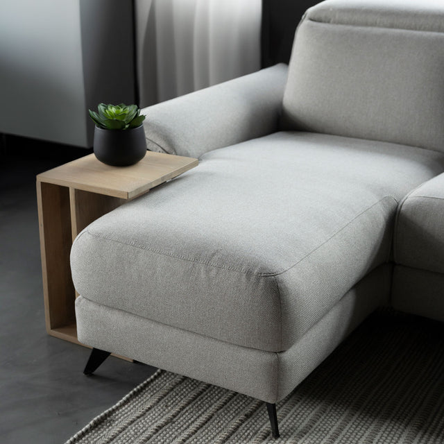 meridienne du canape gris clair en tissu avec table d appoint en bois clair.
