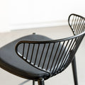 Tabouret de bar noir avec assise rembourrée et dossier ajouré design, idéal pour cuisine moderne.