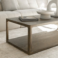 Table basse en bois style minimaliste devant canape beige avec livres et deco moderne.