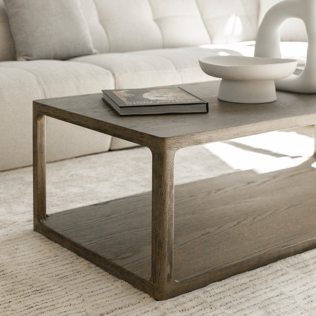 Table basse en bois style minimaliste devant canape beige avec livres et deco moderne.