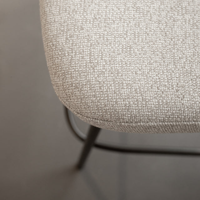 Tabouret de comptoir moderne en tissu beige avec piétement en métal noir, idéale pour cuisine ou îlot contemporain.