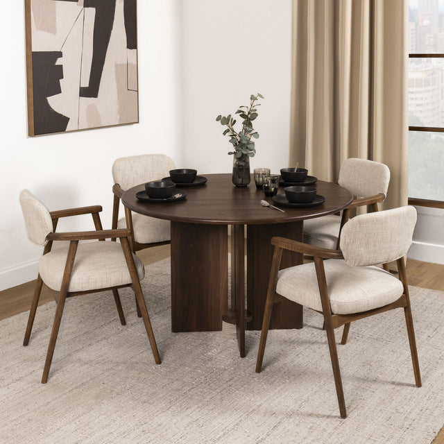 Table à manger ronde en bois foncé avec fauteuils bouclés beige style scandinave.