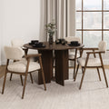 Table à manger ronde en bois foncé avec fauteuils bouclés beige style scandinave.