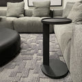 table d'appoint rond noir en metal au design minimaliste.