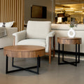 Table d’appoint ronde en bois noyer avec rangement, près d’un fauteuil beige.