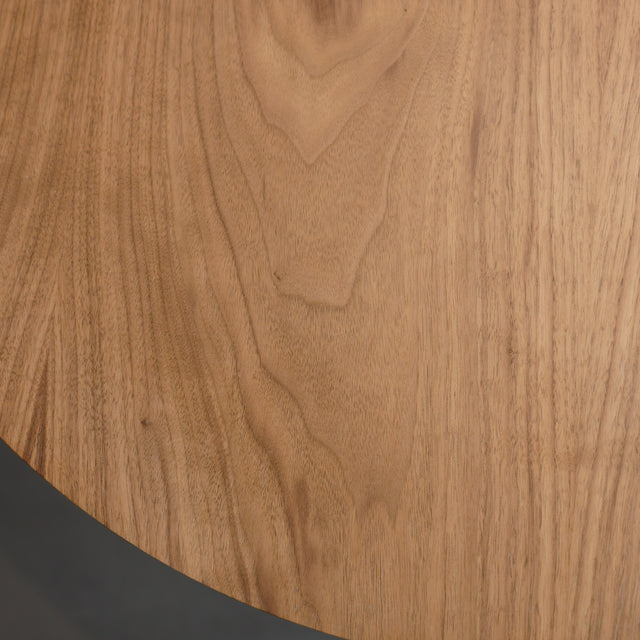 Table basse ronde en bois noyer avec rangement, près d’un fauteuil beige.