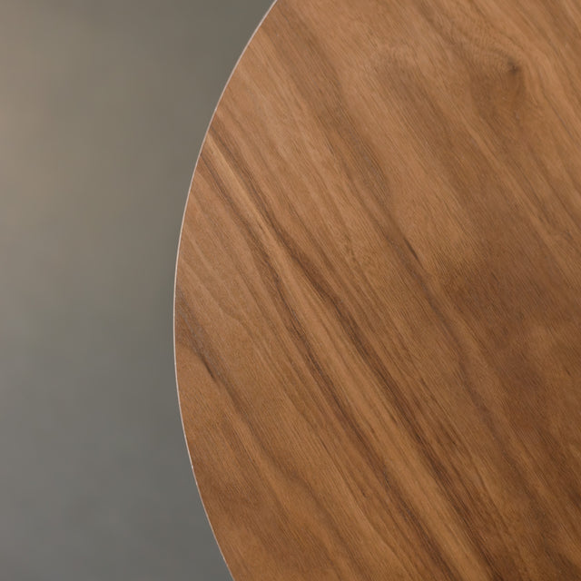 Table basse ronde en bois noyer avec rangement, près d’un fauteuil beige.