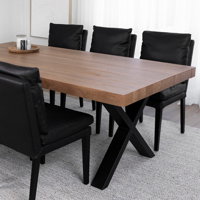Salle a manger elegante avec table en bois massif et chaises noires sur tapis gris.