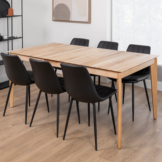 table rectangulaire en bois clair avec chaises noires au design moderne.