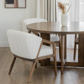 Table ronde en bois avec chaises beige et vase blanc dans deco lumineuse et epuree.
