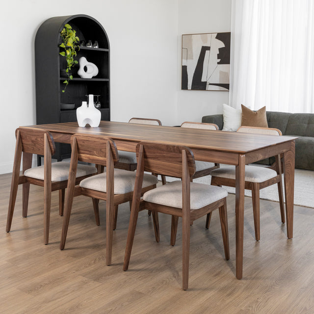 Table a manger en bois noyer avec six chaises beiges dans salle moderne et elegante.