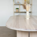 Table ovale en bois clair dans salle a manger lumineuse.