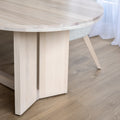 Table ovale en bois clair dans salle a manger lumineuse.