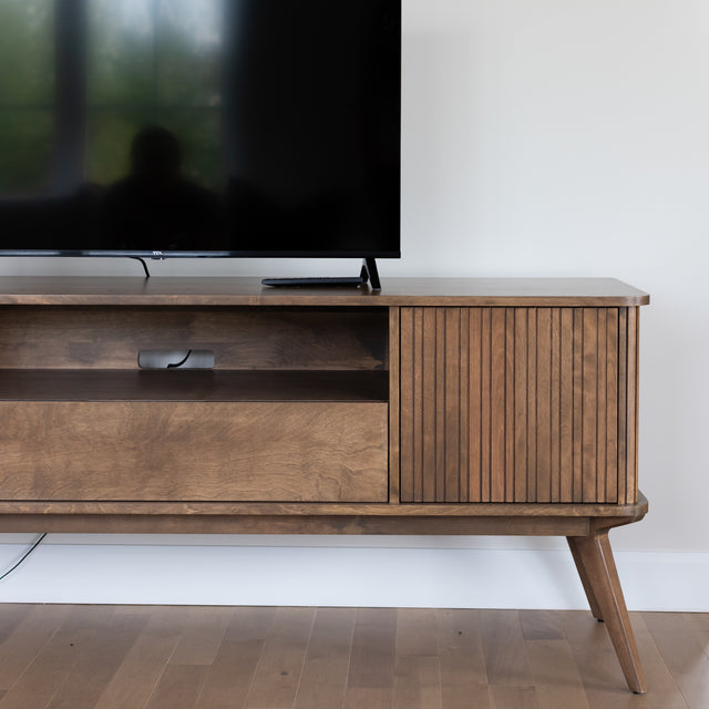 Meuble TV en bois moderne avec rangement et television dans un salon contemporain.