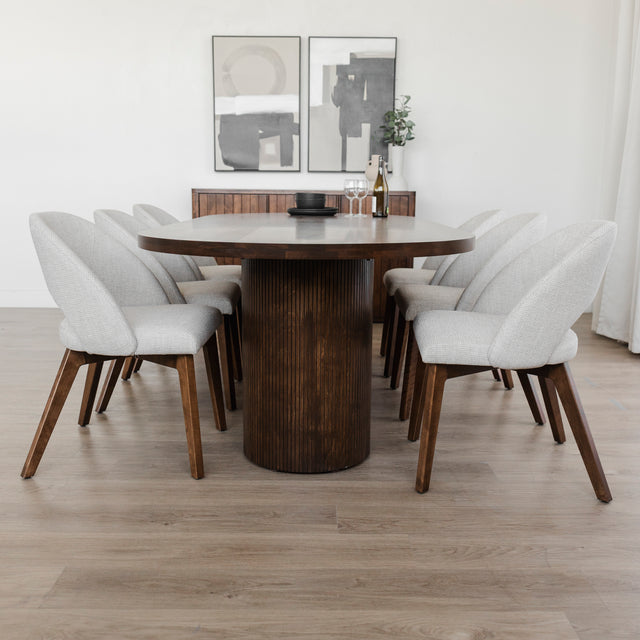 Salle a manger moderne avec table ronde en bois fonce et chaises tissu beige elegantes.

