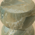 Table d’appoint ronde en pierre verte nervurée, design texturé sculptural pour salon contemporain.