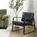 Fauteuil en cuir noir avec structure en métal, présenté dans un salon contemporain à côté d’un canapé en tissu vert.