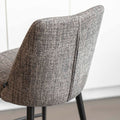 Tabouret de bar design avec assise en tissu brun/gris et pieds en metal noir, ideal pour cuisine moderne.