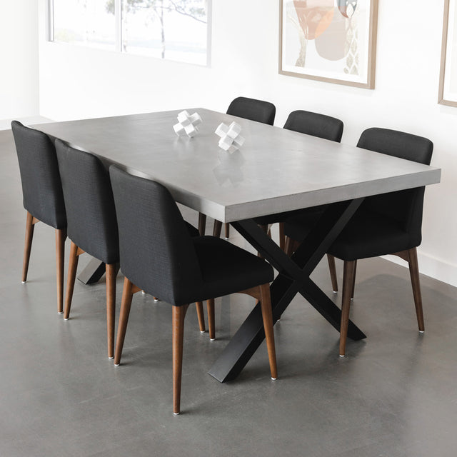 table en beton gris avec pieds croises metalliques noirs et chaises noires.